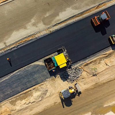 Aerial view on the road rollers working on the new road construction site